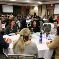 A group of attendees laugh while practicing civil discourse at their table